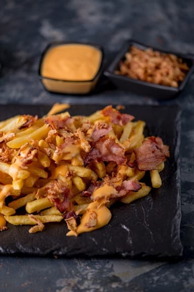 Картопля фрі з смаженою цибулею та беконом